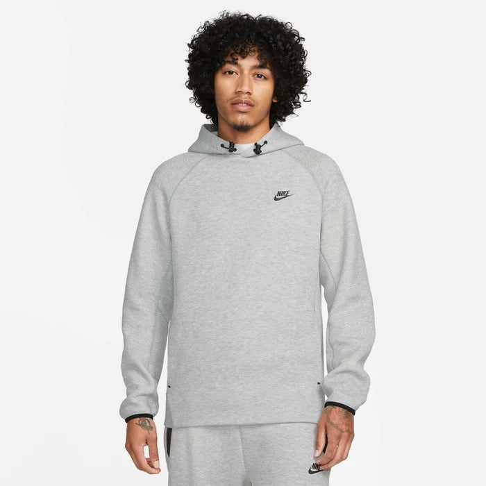 Model wearing the Tech Fleece Men’s Pullover Hoodie in grey — breathable fleece fabric with a clean, minimalist look and signature pullover design.