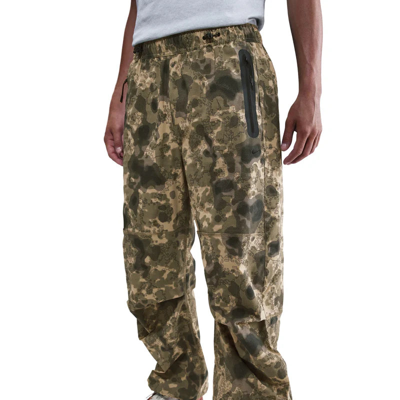 Tech Dri-FIT Woven Camo Loose-Fit Pants featuring relaxed fit, articulated knees, ankle bungee cords, and functional tech pockets in camo design.