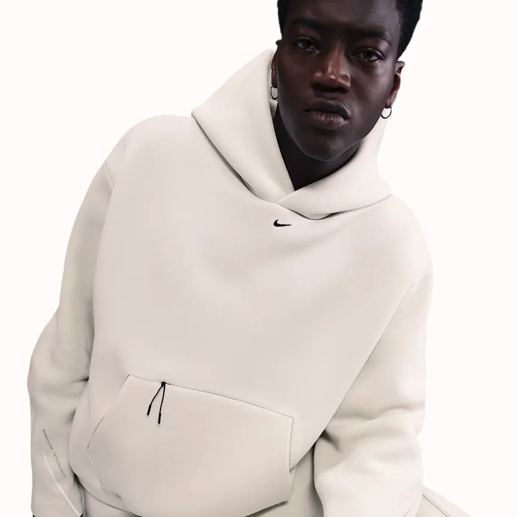 Nike Tech Fleece Oversized Hoodie in light bone white, featuring relaxed fit, front pouch pocket, and minimalist streetwear design.