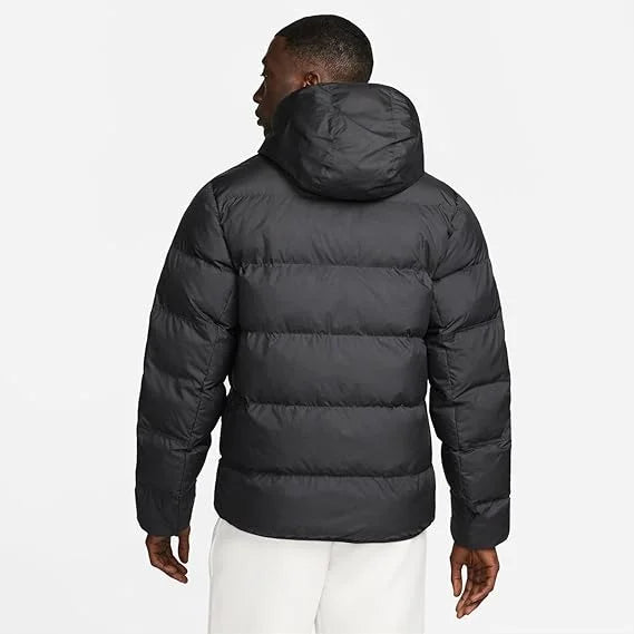 Model wearing Nike Windrunner PrimaLoft Storm-FIT Hooded Puffer Jacket in black – windproof woven shell, water-repellent finish and PrimaLoft ThermoPlume® insulation for cold weather.