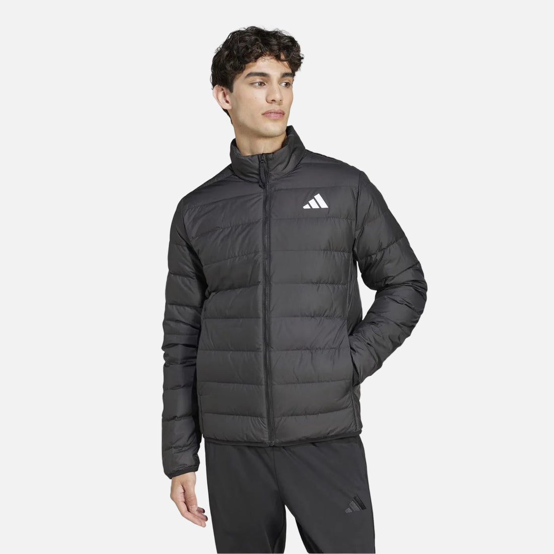 Man wearing black adidas Essentials Light Down Jacket, front view, slim fit down jacket with zip closure and stand-up collar