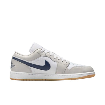 Air Jordan 1 Low Midnight Navy sneaker featuring white leather upper, neutral grey overlays, midnight navy accents, gum rubber outsole, and classic low-top basketball design.