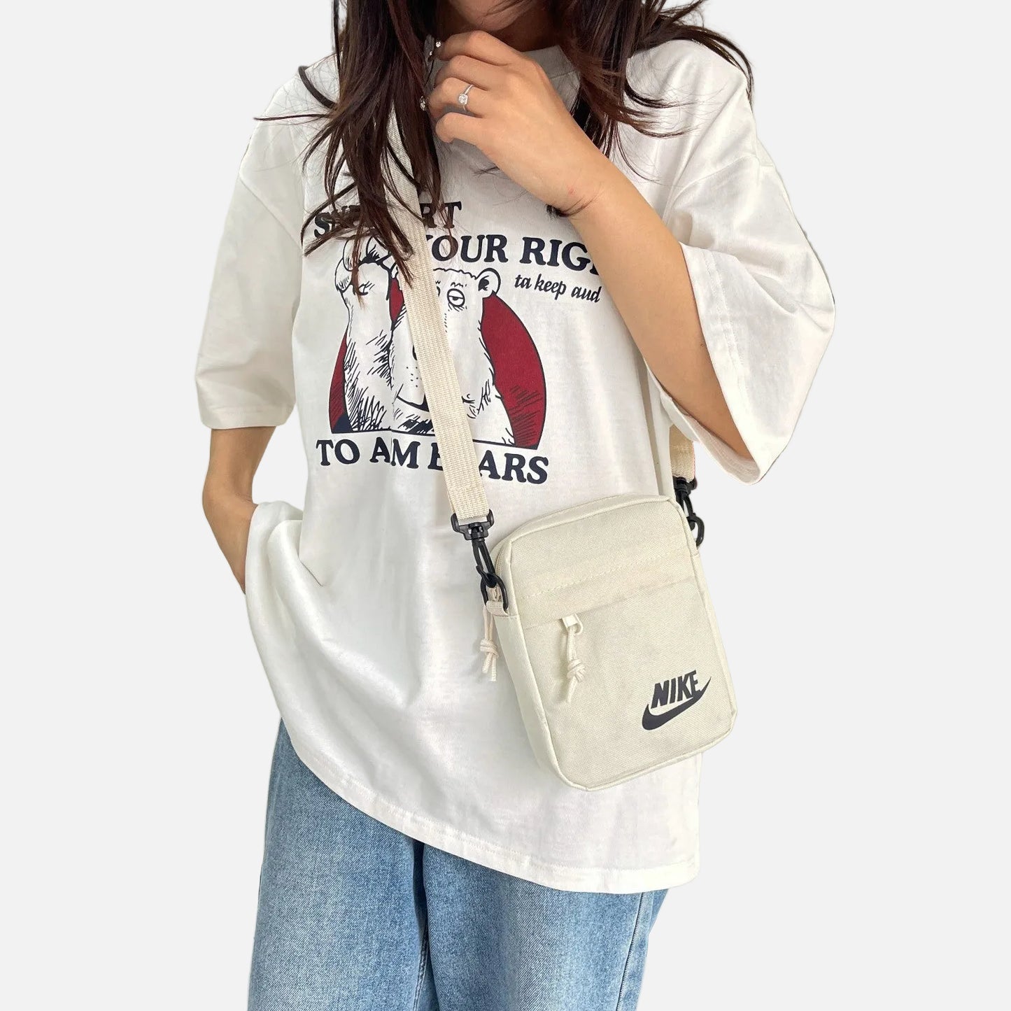 Nike compact crossbody shoulder bags in black, cream, and khaki colors featuring adjustable straps, zip compartments, and the classic Nike logo, designed for everyday carry.