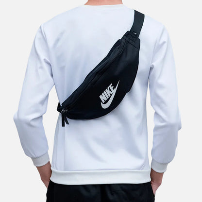 Black Nike Heritage waist bag with adjustable strap, zippered compartments, and white Nike Swoosh logo, designed for everyday crossbody or waist carry.