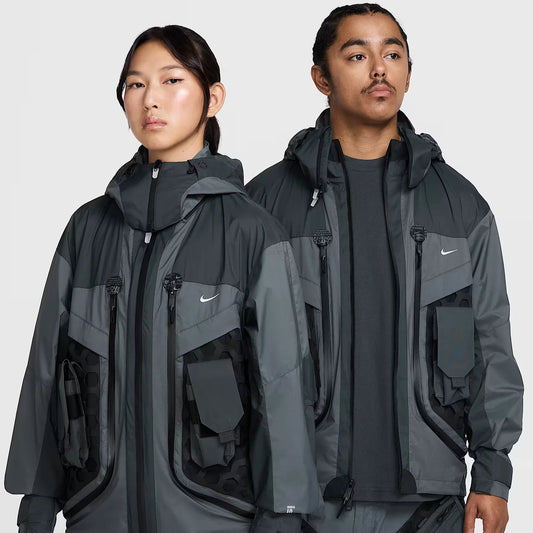 Models showcasing the Nike ISPA Butterfly Jacket in black and gray, featuring a modular design with multiple pockets, technical details, and futuristic streetwear style.