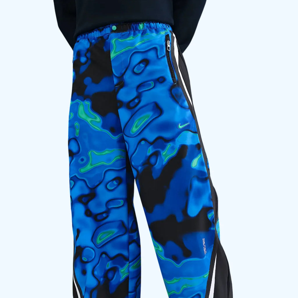 Nike Project F.R.O.G. Men’s Track Pants featuring bold blue and green abstract pattern, lightweight fabric and modern athletic style.