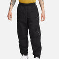 Nike Solo Swoosh Men’s Track Pants in black, front view. Features elastic waistband, side pockets, relaxed fit and reflective piping for modern athletic style.