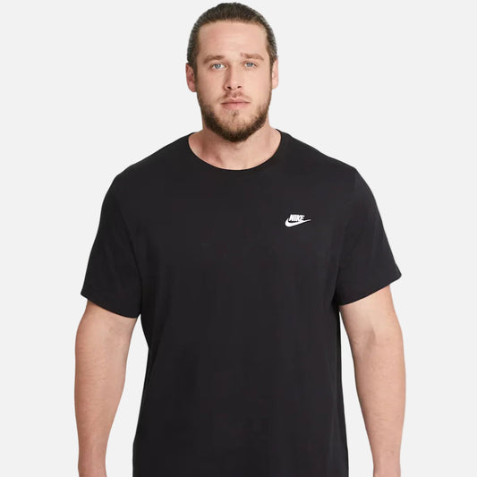 Man wearing Nike Sportswear Club T-Shirt in black/white — 100% cotton crew-neck with embroidered Futura logo on chest, relaxed fit for everyday wear.