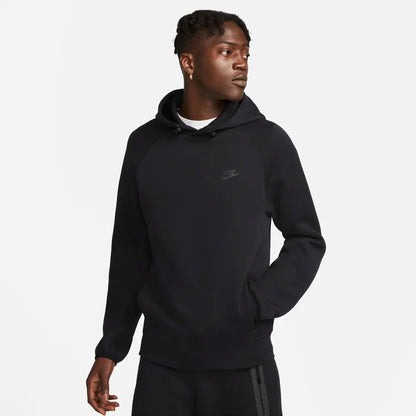 Model wearing the Tech Fleece Men’s Pullover Hoodie in black — soft, lightweight fleece with a smooth finish and adjustable hood for everyday comfort.