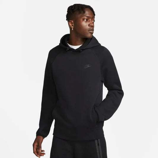 Model wearing the Tech Fleece Men’s Pullover Hoodie in black — soft, lightweight fleece with a smooth finish and adjustable hood for everyday comfort.