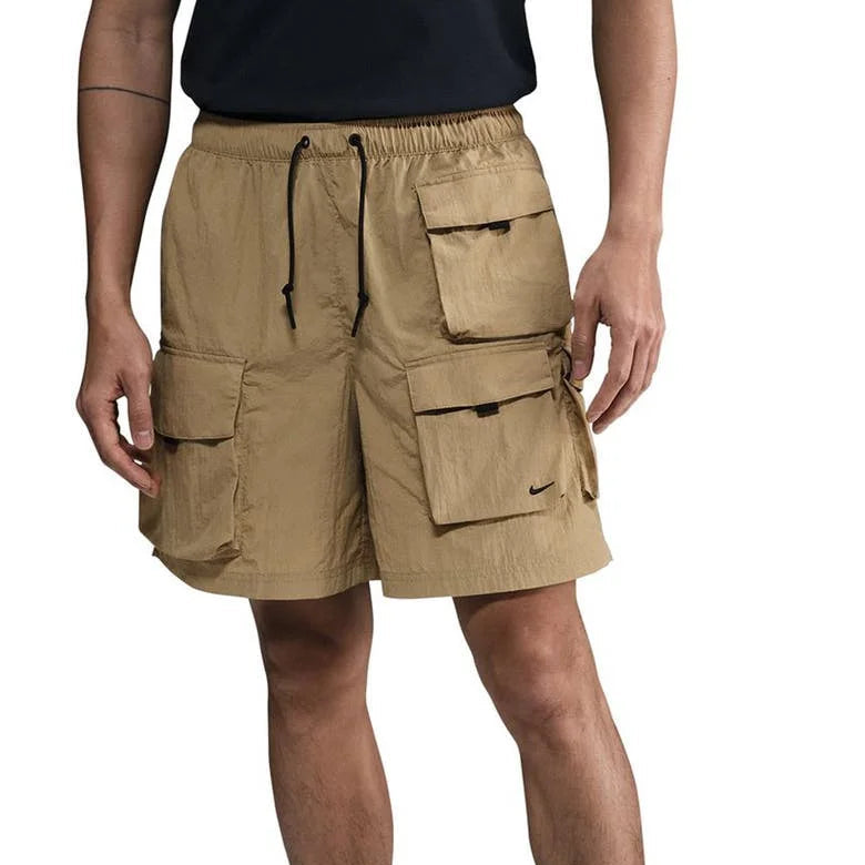 Man wearing Nike Tech Woven Cargo Shorts in beige with multiple utility pockets and modern fit, designed for urban style and everyday comfort.