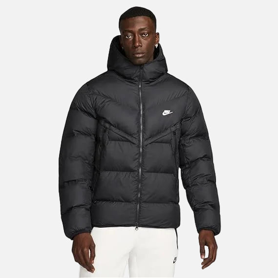 Model wearing Nike Windrunner PrimaLoft Storm-FIT Hooded Puffer Jacket in black – windproof woven shell, water-repellent finish and PrimaLoft ThermoPlume® insulation for cold weather.