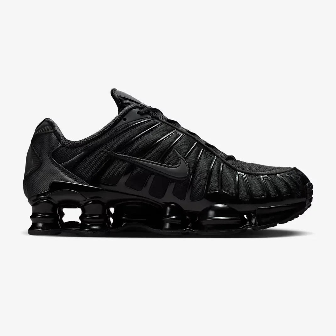 Nike Shox TL Triple Black sneaker featuring full-length Shox cushioning columns, breathable black mesh upper, molded overlays, and sleek monochrome athletic design.