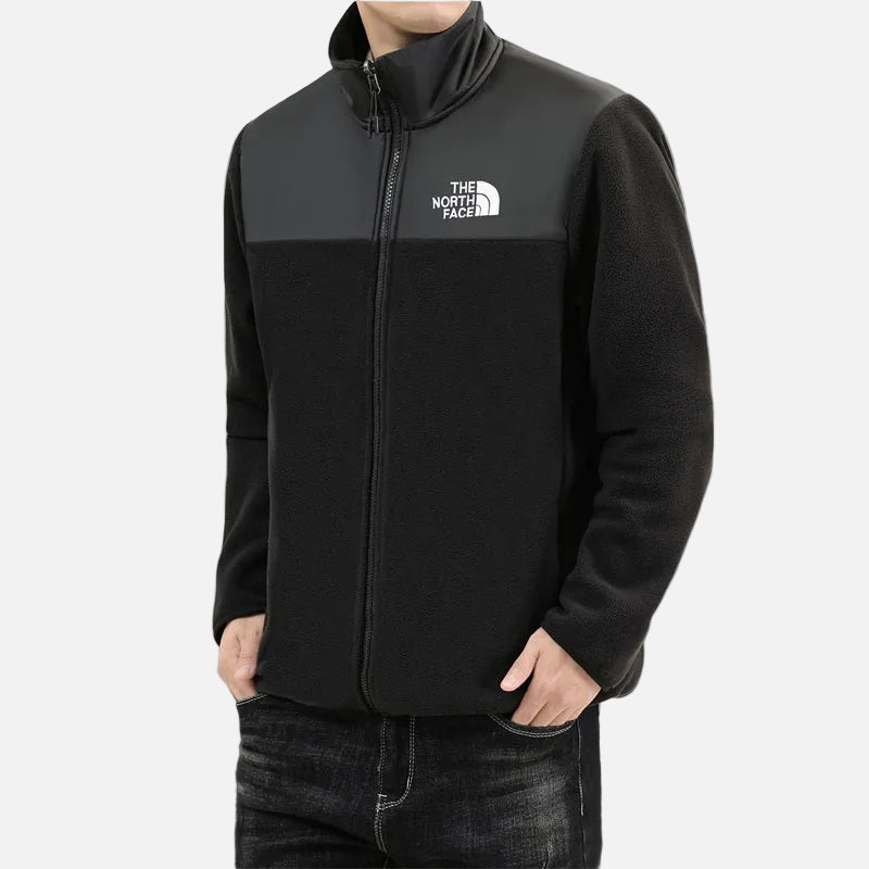 Front view of men’s black fleece jacket with full zip, high collar and woven chest panel.