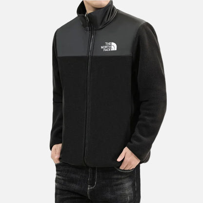 Front view of men’s black fleece jacket with full zip, high collar and woven chest panel.