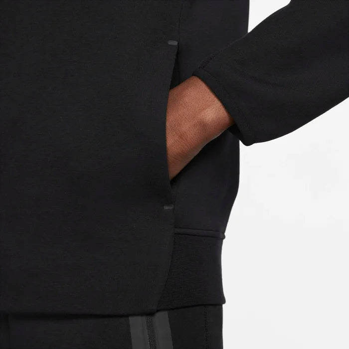 Model wearing the Tech Fleece Men’s Pullover Hoodie in black — soft, lightweight fleece with a smooth finish and adjustable hood for everyday comfort.