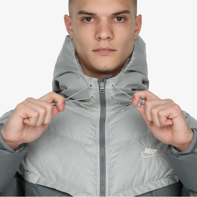 Model wearing Nike Windrunner PrimaLoft Storm-FIT Hooded Puffer Jacket in black – windproof woven shell, water-repellent finish and PrimaLoft ThermoPlume® insulation for cold weather.